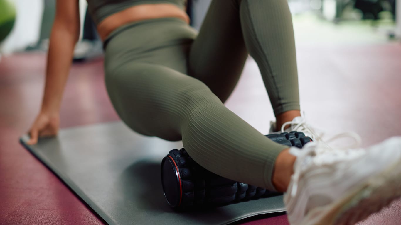 A woman trains with a foam roller.
