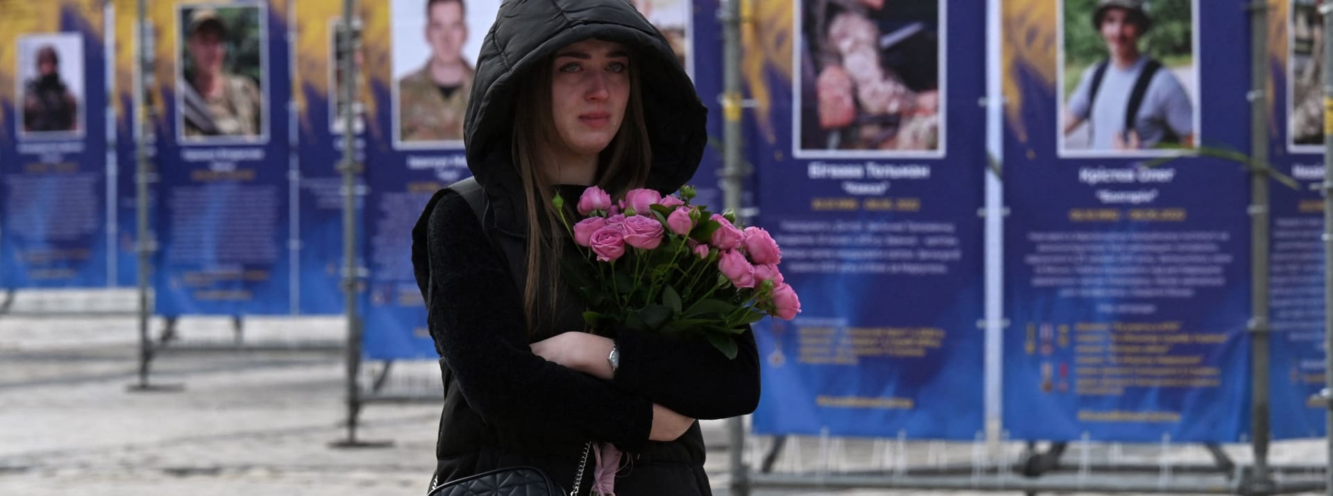 14. Oktober: Es ist der Tag der Verteidigerinnen und Verteidiger der Ukraine. Eine junge Frau steht vor einer Straßenaustellung in Kiew. Gezeigt werden die Porträts und Geschichten derjenigen, die in der Schlacht um Mariupol ums Leben kamen.