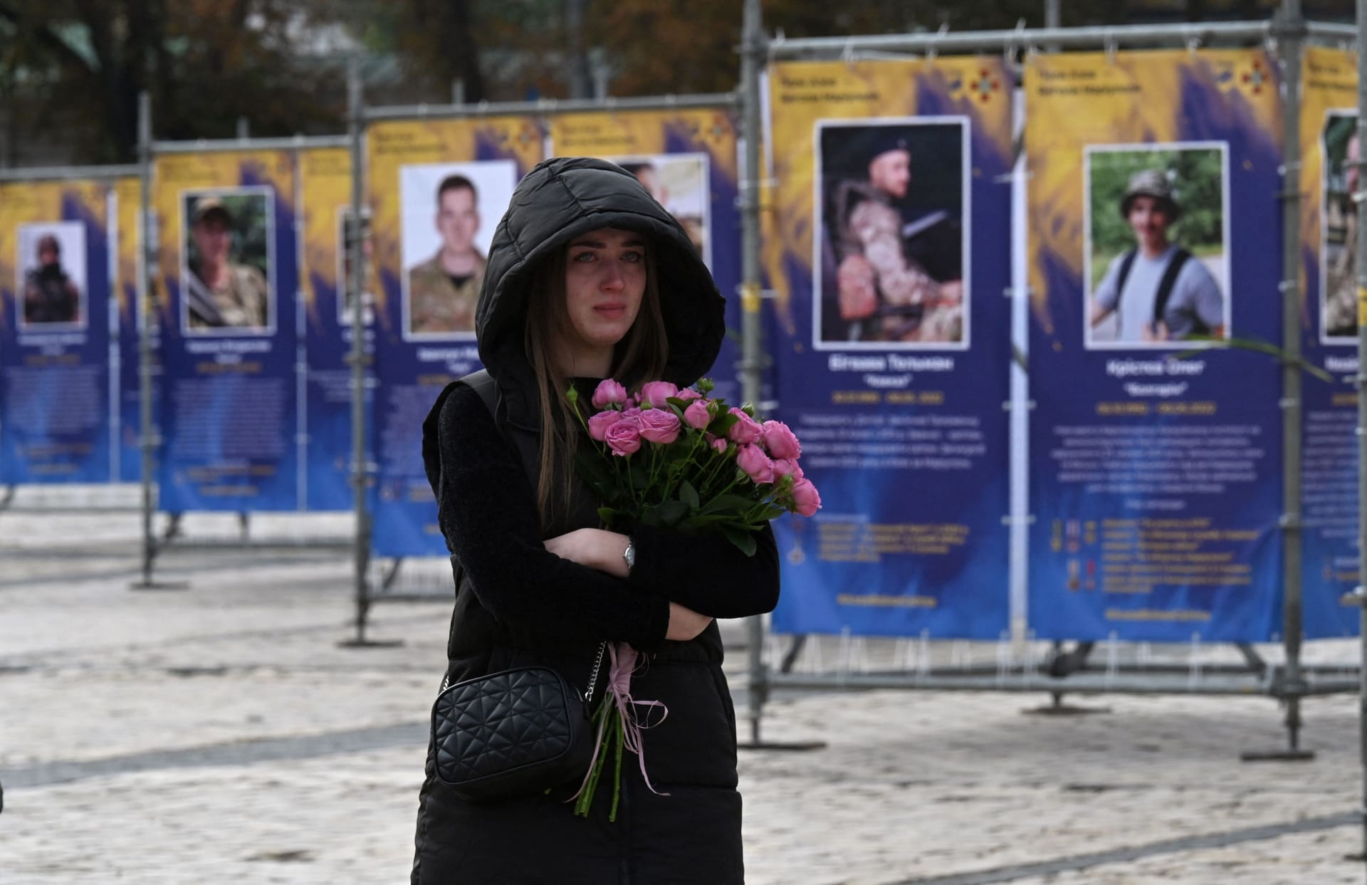 14. Oktober: Es ist der Tag der Verteidigerinnen und Verteidiger der Ukraine. Eine junge Frau steht vor einer Straßenaustellung in Kiew. Gezeigt werden die Porträts und Geschichten derjenigen, die in der Schlacht um Mariupol ums Leben kamen.