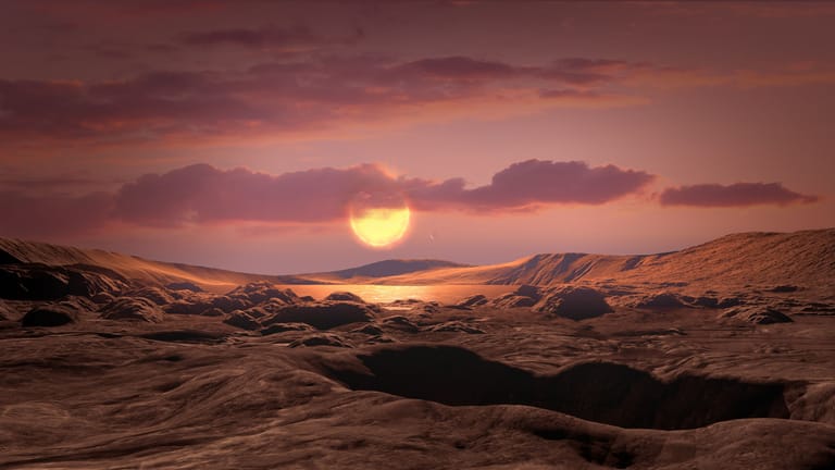 Die Sonne "Wolf 1069" vom Exoplaneten "Wolf 1069 b" aus gesehen: So stellt sich ein Künstler die Oberfläche des Planeten und den Blick auf seinen Stern vor.