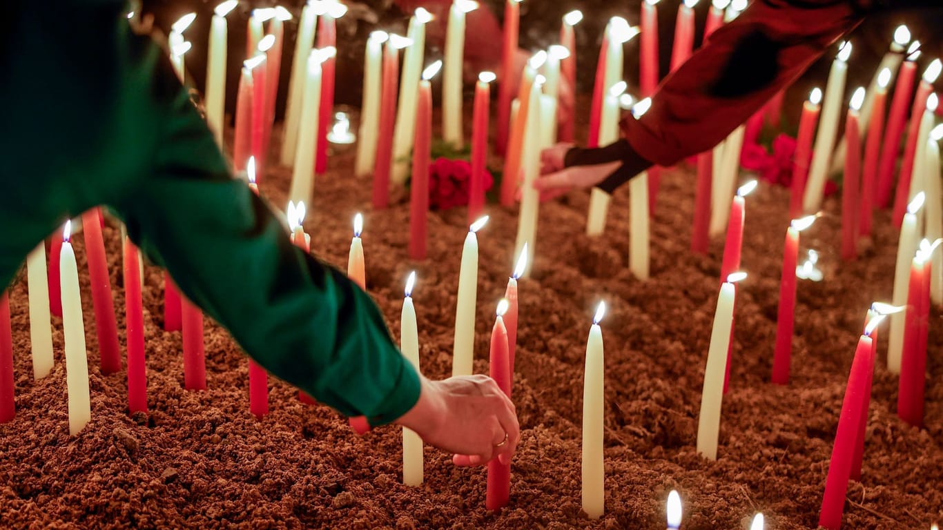 Teilnehmer der Andacht stellen Kerzen auf (Archivbild): Bei der Messerattacke starben zwei junge Menschen.
