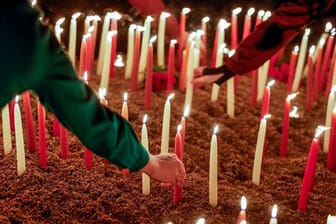 Teilnehmer der Andacht stellen Kerzen auf (Archivbild): Bei der Messerattacke starben zwei junge Menschen.