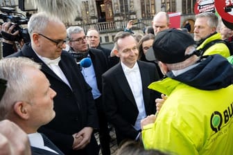 Volker Wissing (FDP, Mitte), Bundesverkehrsminister, und Andreas Bovenschulte (SPD), Bürgermeister von Bremen, sprechen mit Aktivisten, die gegen die Verkehrspolitik demonstrieren.