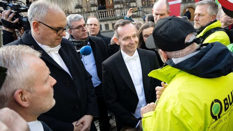 Volker Wissing (FDP, Mitte), Bundesverkehrsminister, und Andreas Bovenschulte (SPD), Bürgermeister von Bremen, sprechen mit Aktivisten, die gegen die Verkehrspolitik demonstrieren.