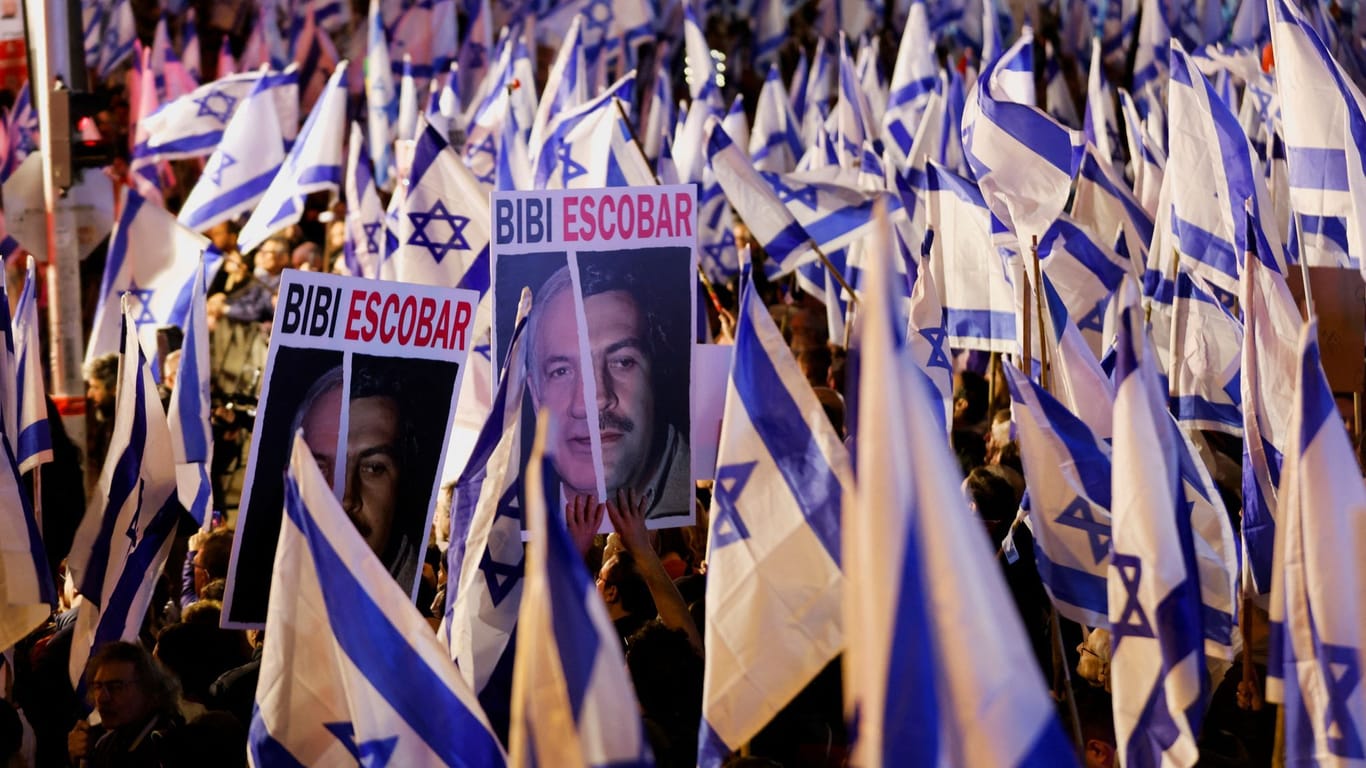 Demonstranten halten Protestplakate gegen Ministerpräsident Benjamin Netanjahu hoch.