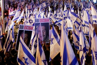 Demonstranten halten Protestplakate gegen Ministerpräsident Benjamin Netanjahu hoch.