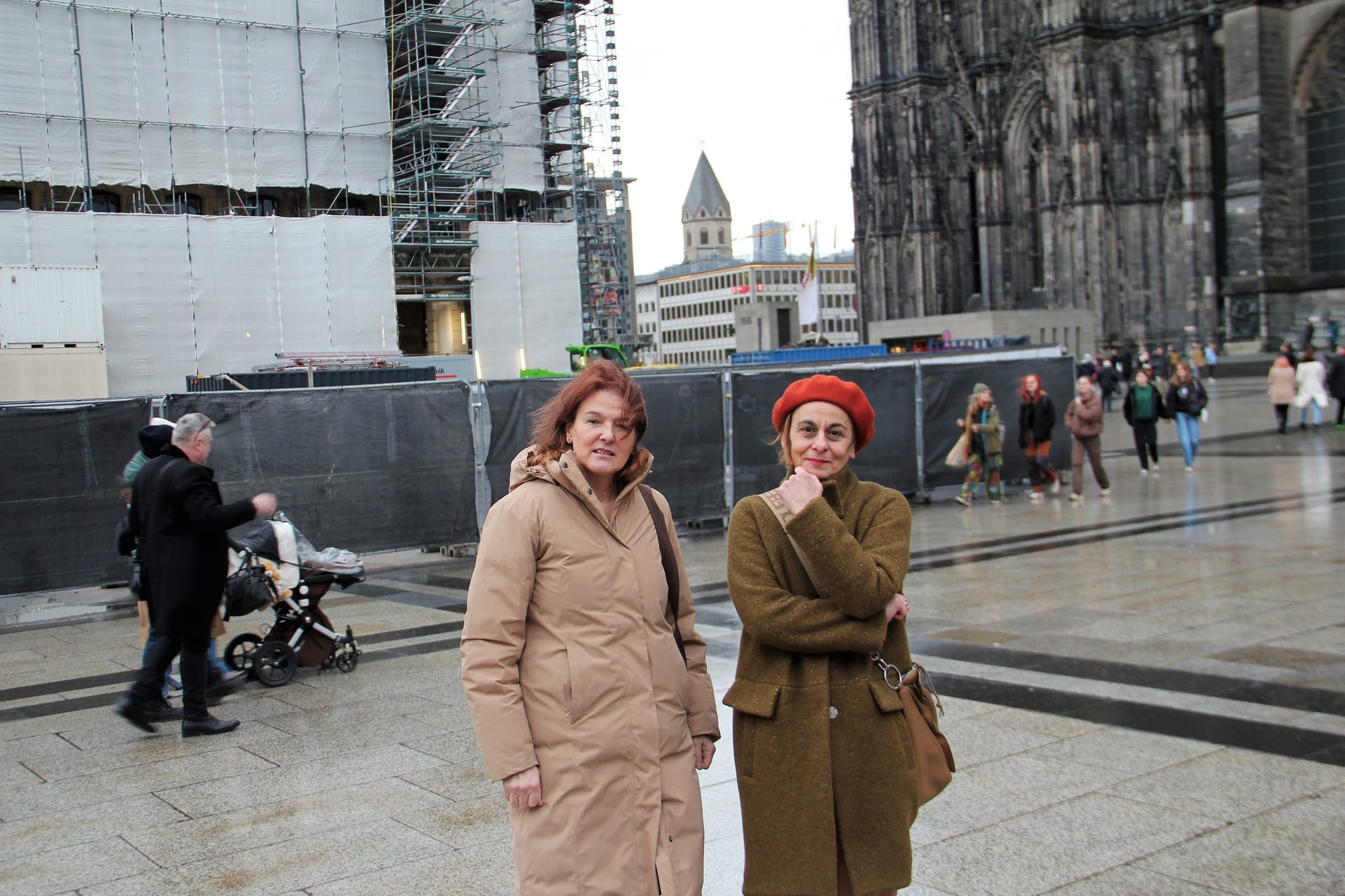 Die Stadtführerinnen Angela Schlösser (l.) und Parthena Pauli kritisieren unter anderem das triste Erscheinungsbild an langwierigen Baustellen, wie etwa dem Dom-Hotel, sowie das Fehlen von Überquerungshilfen im unmittelbaren Domumfeld, beispielsweise hinter dem Römerweg Richtung Philharmonie.