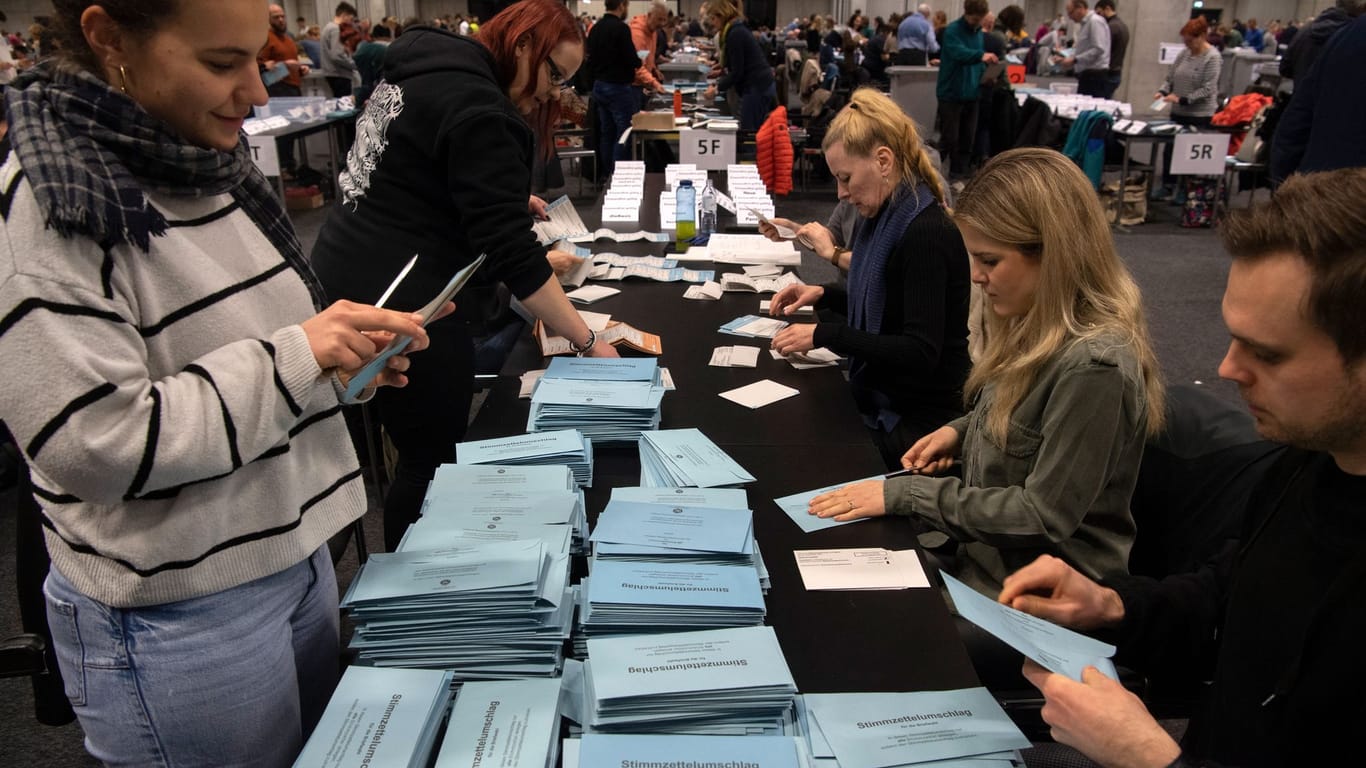 Mehrere Personen sichten die Stimmzettel der Briefwähler: In Lichtenberg sind ungezählte Briefwahlzettel aufgetaucht.