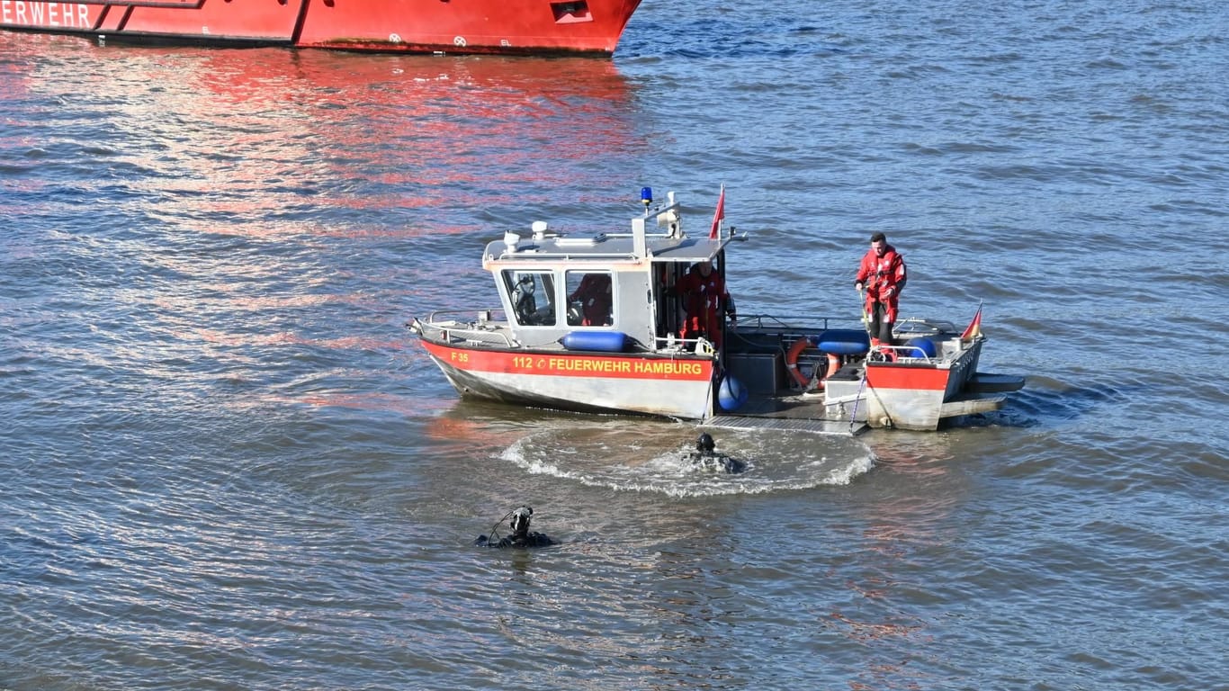 Taucher der Feuerwehr Hamburg suchen in der Elbe nach einem Kind: Der Junge soll von einem Fähranleger ins Wasser gekommen sein.