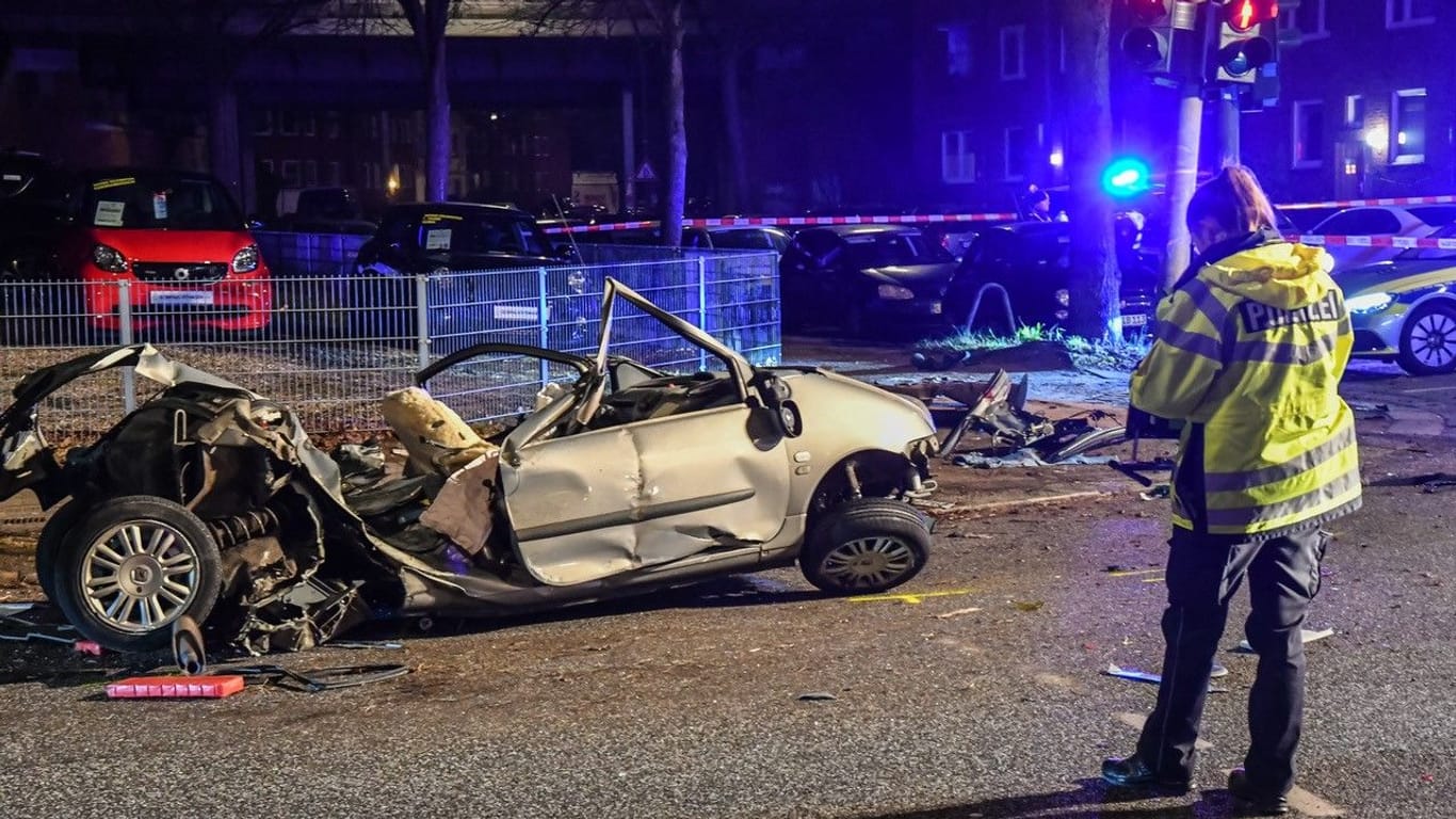 Eine Polizistin neben dem zerstörten Auto: Der Fahrer war offensichtlich zu schnell unterwegs.