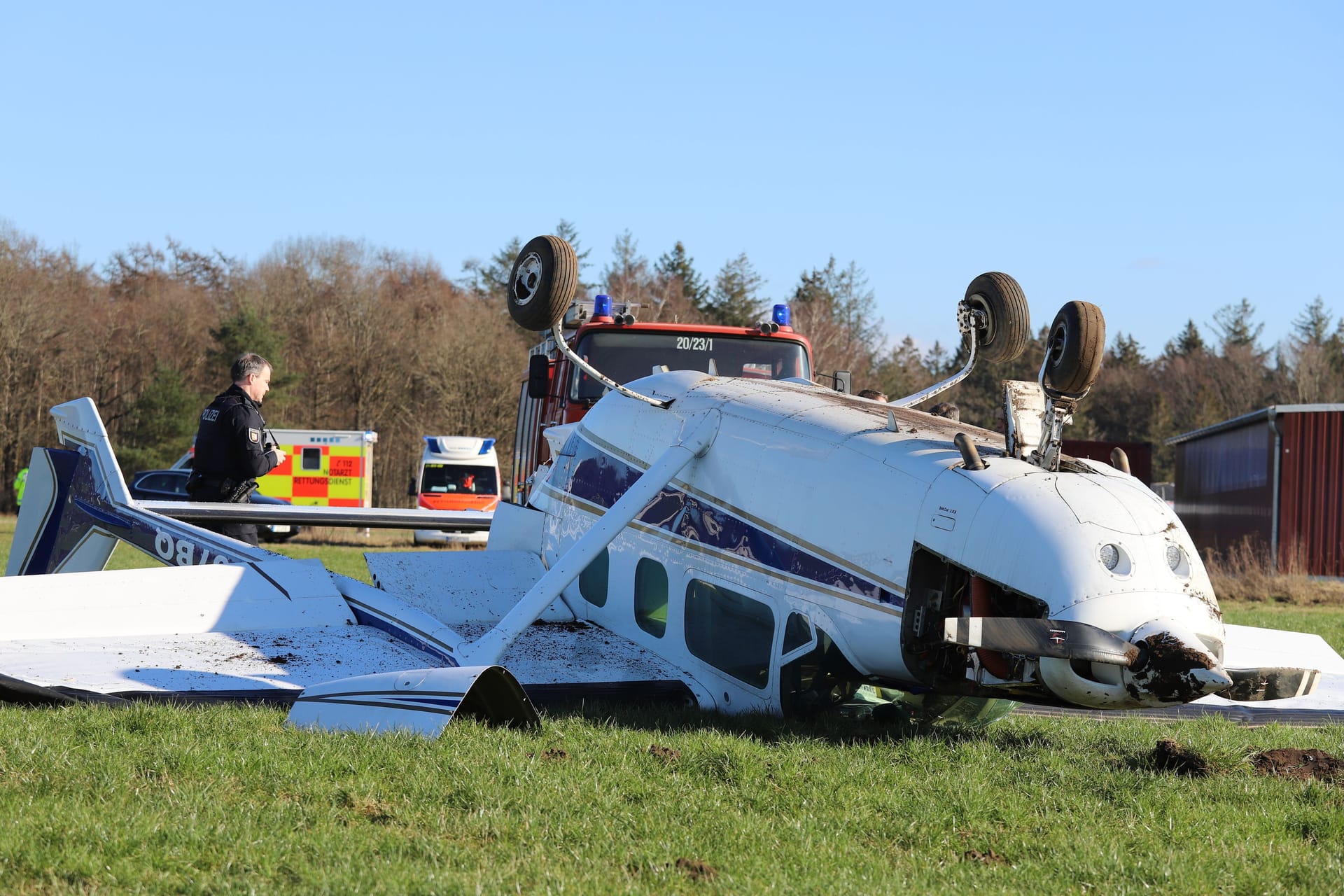 Das Flugzeug liegt auf dem Dach neben dem Rollfeld: Der Pilot kam mit leichten Verletzungen davon.