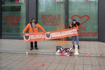 Die beiden Aktivisten halten ein Transparent mit der Aufschrift: "Art. 20a GG = Leben schützen": Sie protestieren gegen fossile Brennstoffe.