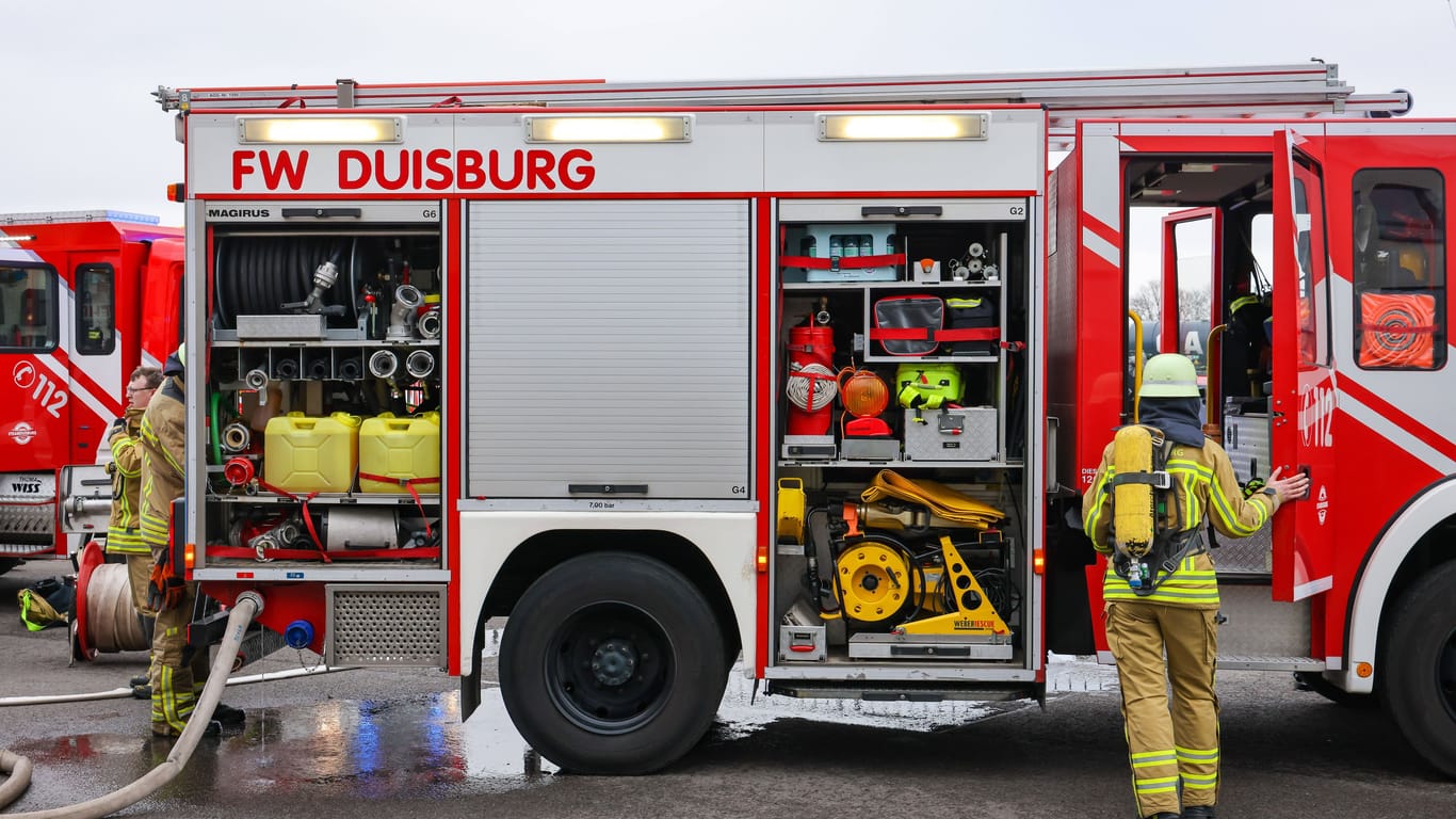 Eine Feuerwehrfrau geht zum Feuerwehrwagen (Archivbild): Bei einem Einsatz in Hamburg wurde eine Frau gerettet.