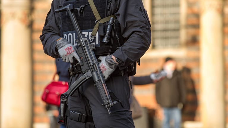 Ein Polizeibeamter mit Schusswaffe (Symbolbild): In Berlin wurde eine Tür gesprengt.