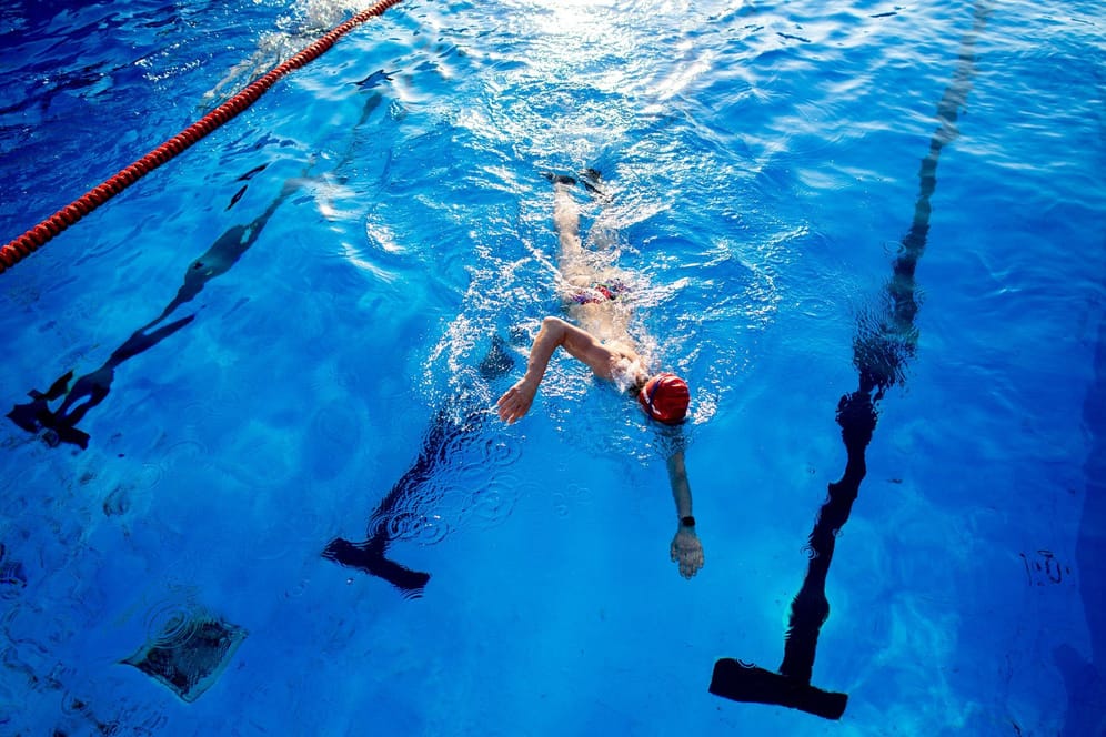 Eine Frau schwimmt durch das Becken eines Hallenbades (Symbolfoto): Der Appell, Energie zu sparen, gilt laut Bäderland weiterhin.