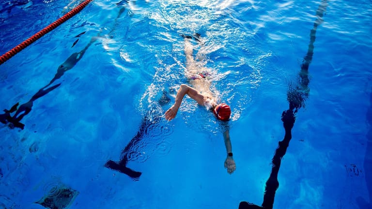Eine Frau schwimmt durch das Becken eines Hallenbades (Symbolfoto): Der Appell, Energie zu sparen, gilt laut Bäderland weiterhin.