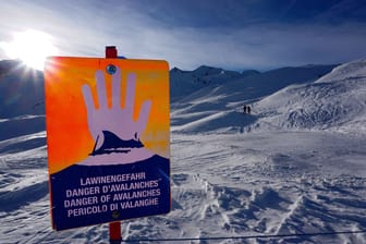 Ein Schild warnt vor Lawinen in den verschneiten Alpen (Symbolbild): Viel Neuschnee erhöht die Gefahr nun auch wieder in Bayern.
