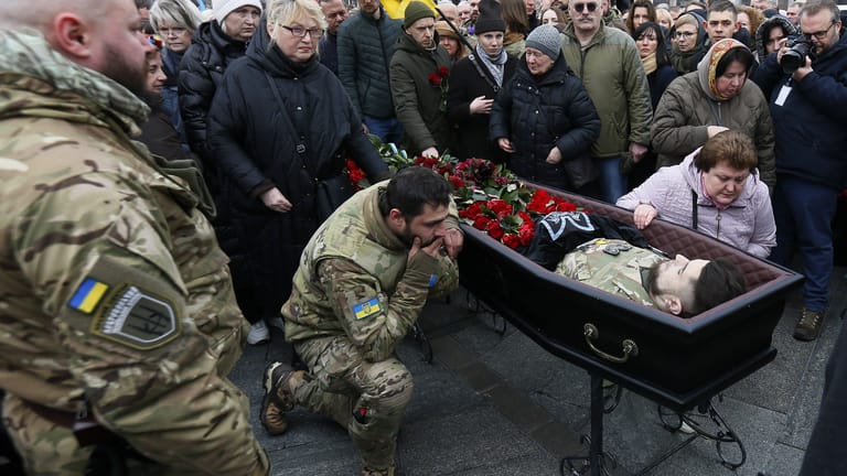 Menschen versammeln sich um den Sarg mit dem Leichnam des ukrainischen Soldaten Dmytro Kotsiubailo: Kotsiubailo war in einem Gefecht an der Frontlinie bei Bachmut gefallen.