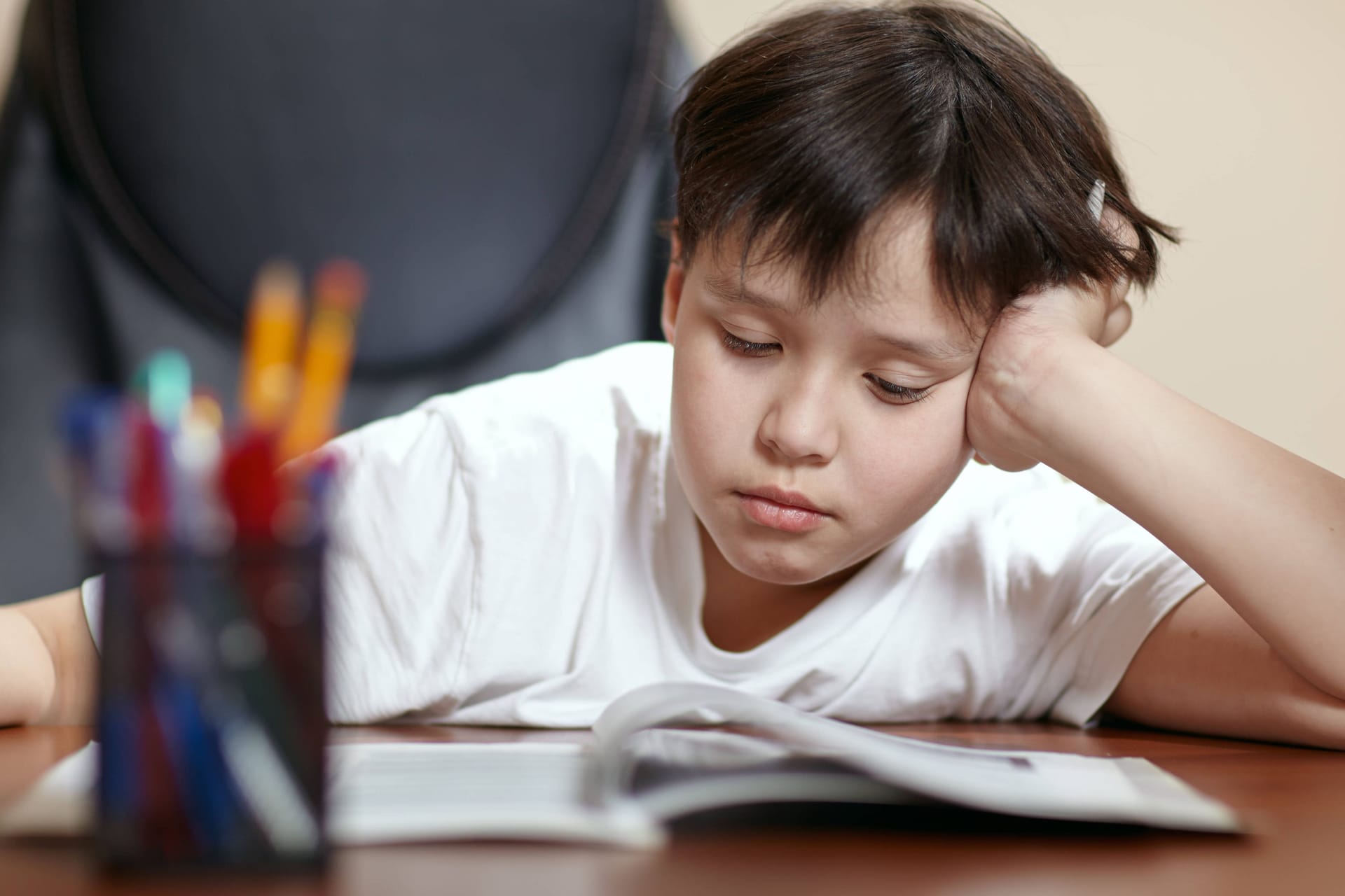 Ein Schüler schaut traurig auf seine Hausaufgaben (Symbolbild): Ärzte schlagen Alarm wegen der aktuell schlechten Versorgung von Kindern und Jugendlichen mit psychischen Problemen.