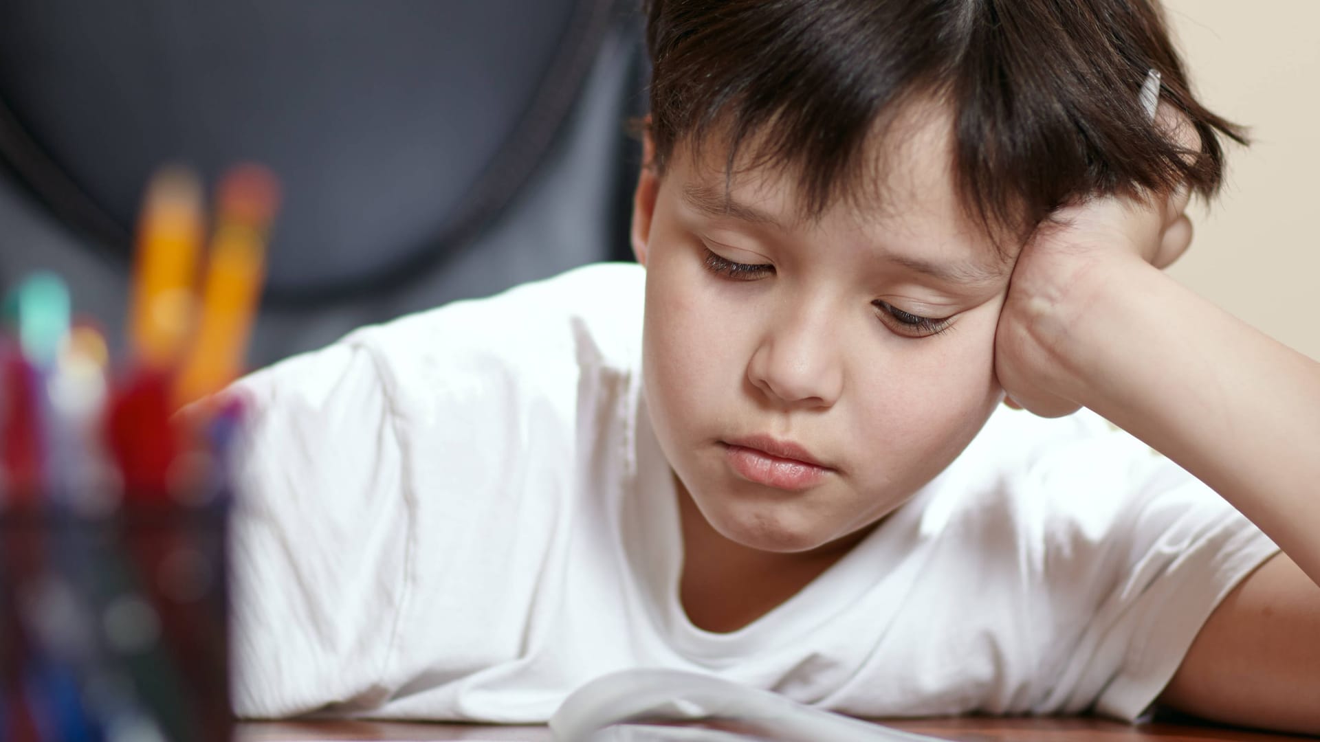 Ein Schüler schaut traurig auf seine Hausaufgaben (Symbolbild): Ärzte schlagen Alarm wegen der aktuell schlechten Versorgung von Kindern und Jugendlichen mit psychischen Problemen.