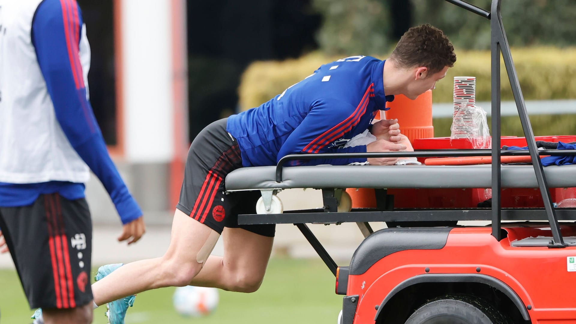 imago images 1010624709Benjamin Pavard springt auf ein Fahrzeug auf dem Trainingsplatz des FC Bayern (Archivbild): Auch im Straßenverkehr ist er vorerst nur als Beifahrer unterwegs.