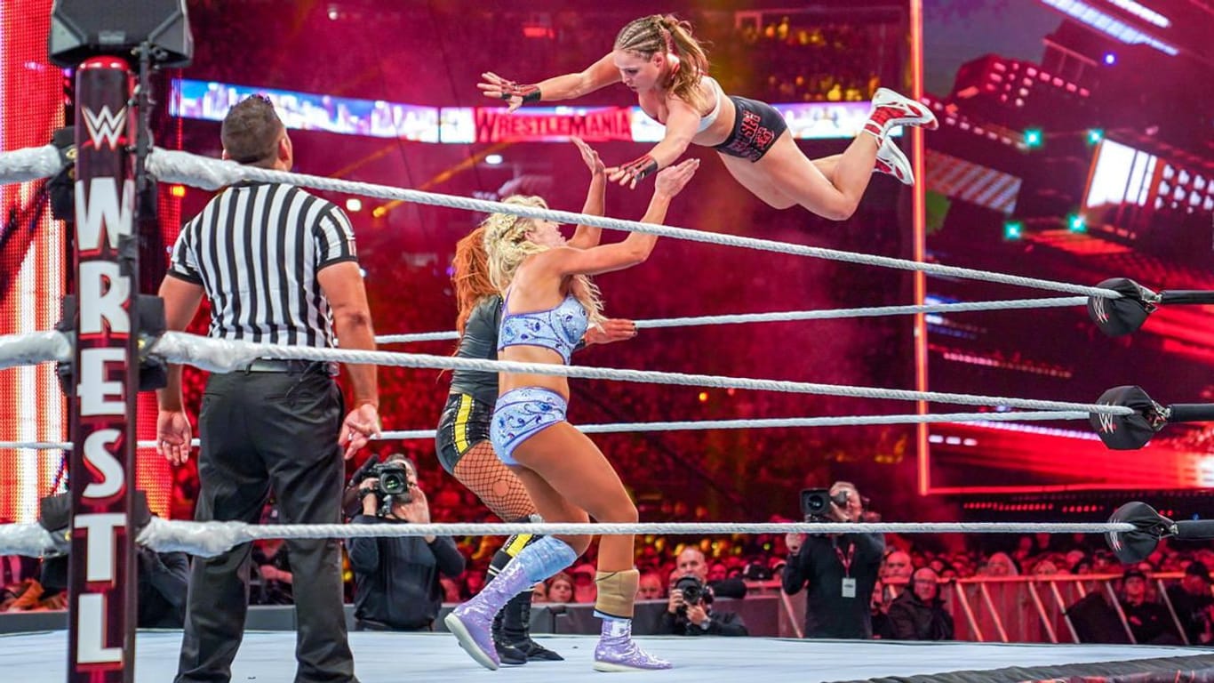 WWE Bildunterschrift: Geschichte geschrieben: Becky Lynch, Charlotte Flair und Ronda Rousey (v. li.) standen 2019 als erste Frauen im Hauptmatch von Wrestlemania.