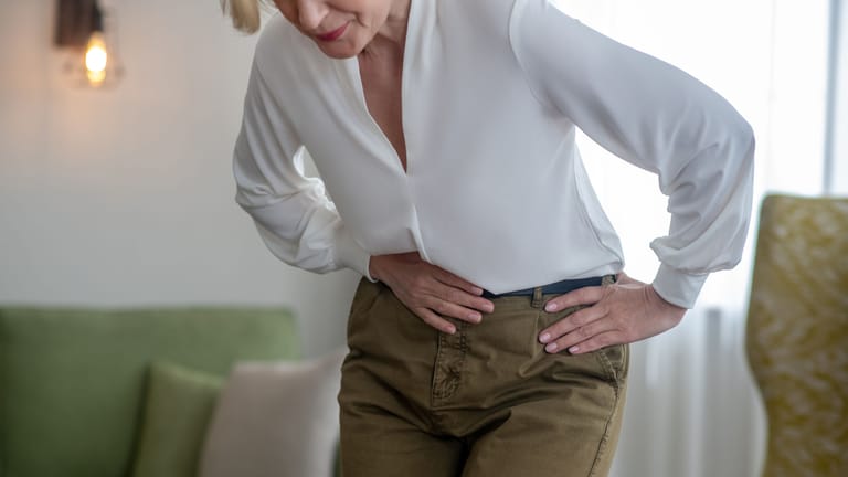 Frau mit Bauchschmerzen: Die akute intermittierende Porphyrie kommt selten vor. Wegen ihrer auf den ersten Blick unspezifischen Symptome wie starken Bauchschmerzen wird sie oft lange verkannt.