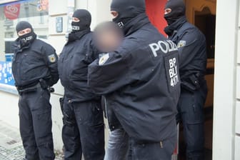 Razzia in Berlin: Polizisten führen einen tatverdächtigen Mann ab.