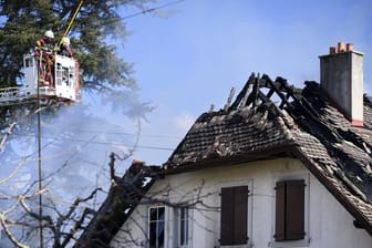 Yverdon-Les-Bains (Schweiz): Feuerwehrleute beobachten von einer Leiter aus eine Villa, in der nach einem Brand Leichen gefunden wurden.