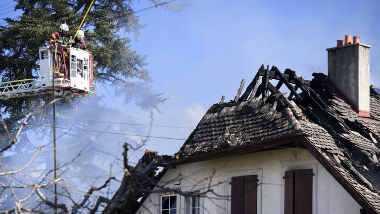 Yverdon-Les-Bains (Schweiz): Feuerwehrleute beobachten von einer Leiter aus eine Villa, in der nach einem Brand Leichen gefunden wurden.