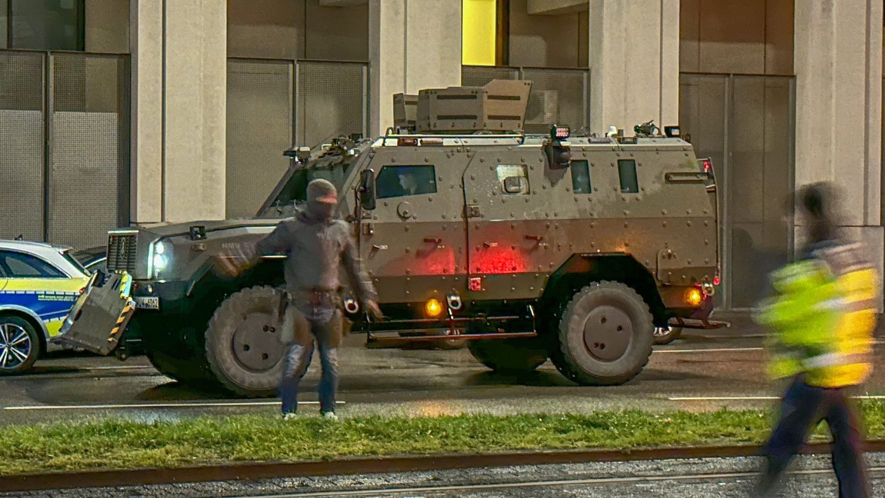 Ein Polizist in Spezialausrüstung steht vor einem stark gepanzerten Spezialfahrzeug: In einer Apotheke wurden eine oder mehrere Geiseln genommen.