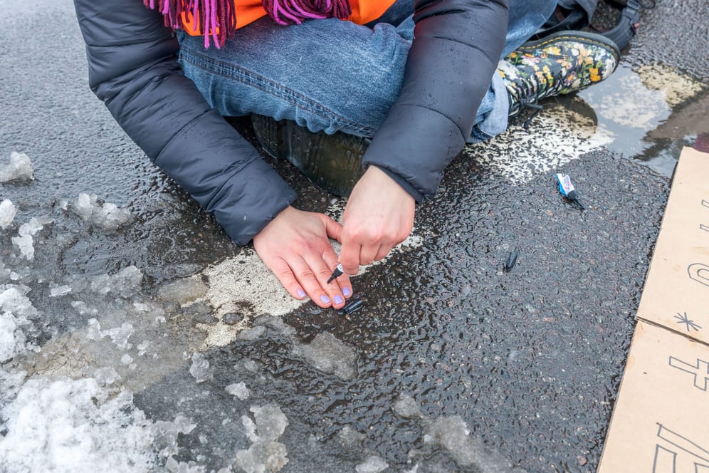 Aktivistin klebt sich an die Straße: Die Klimaschutzbewegung wird "täglich genau" geprüft, heißt es.