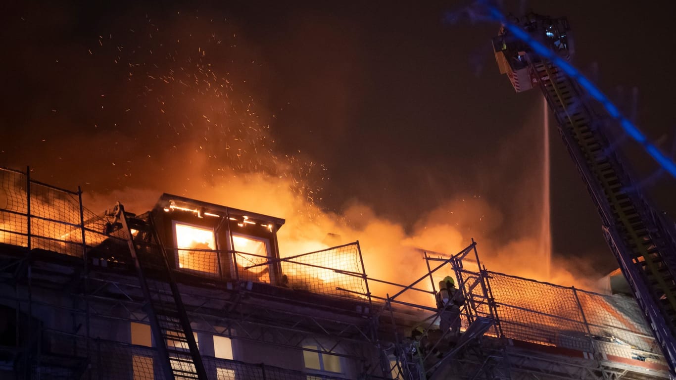 Der brennende Dachstuhl: Ein Feuerwehrmann löscht von einer Drehleiter aus.