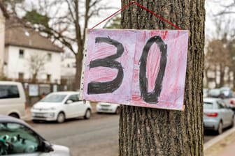 Ein selbstgemaltes 30er-Schild an einem Baum in Berlin (Symbolbild): Wie man sieht, protestieren nicht nur in Grünwald Menschen für 30er-Zonen.