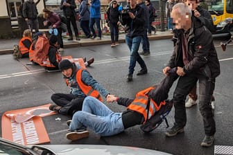 Aktion der "Letzten Generation" in Dresden: Ein Autofahrer zieht einen Klimaaktivisten von der Straße.