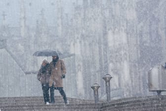 Wintereinbruch in Köln: Ein Paar steht vor dem Kölner Dom im Schnee.