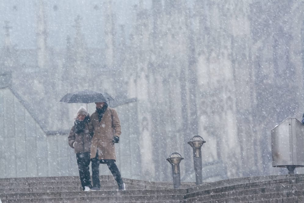 Wintereinbruch in Köln: Ein Paar steht vor dem Kölner Dom im Schnee.