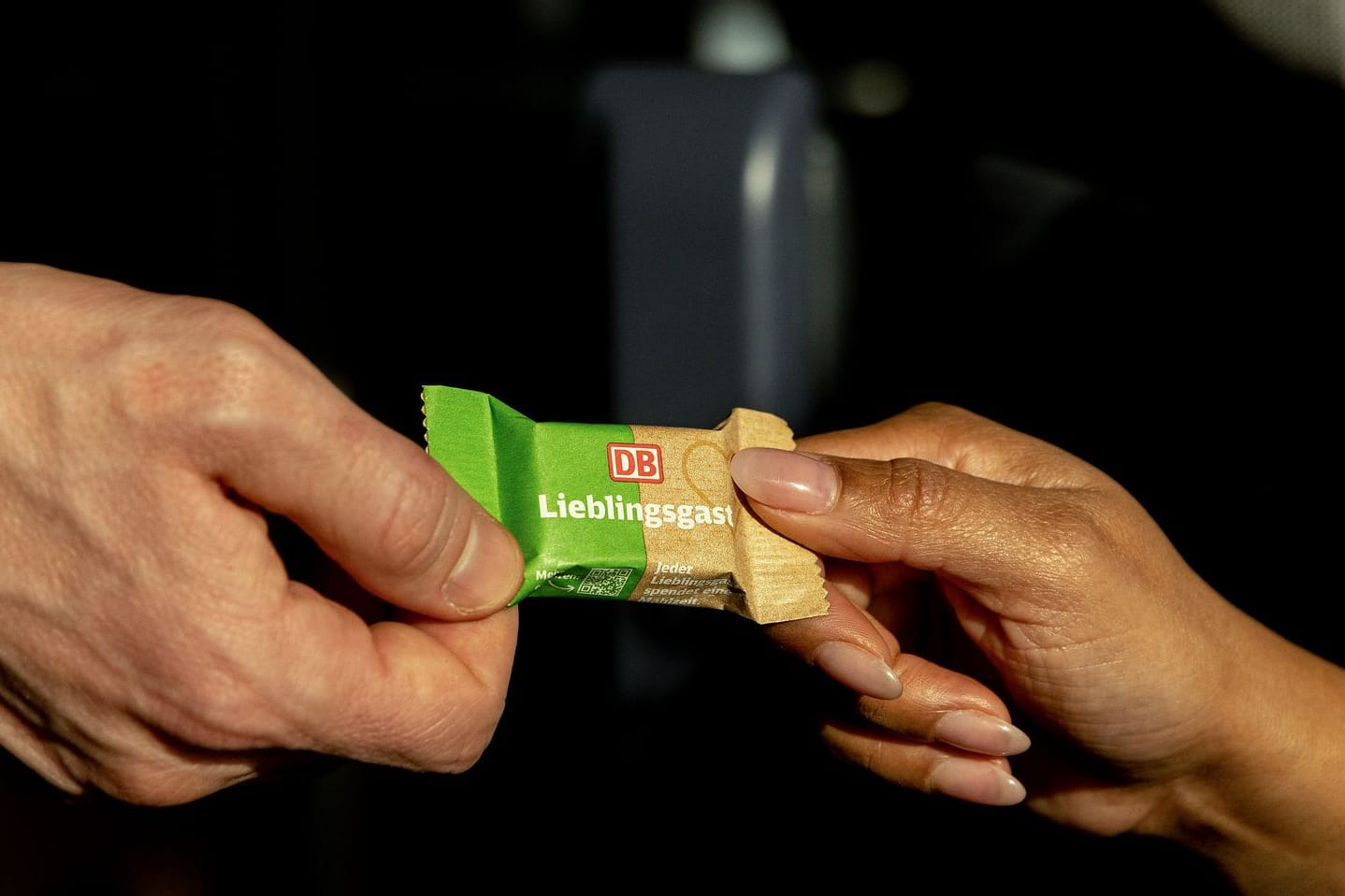 Ein Täfelchen "Lieblingsschokolade" von Share geht von Hand zu Hand. Die Deutsche Bahn gibt diese Schokolade ab jetzt in der 1. Klasse aus - für einen guten Zweck.