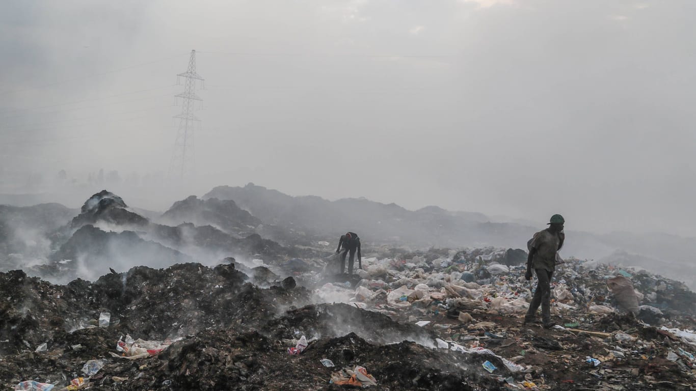 Müllsammler in Kenia sammeln Plastik, Textilien und andere Abfälle auf einer Mülldeponie: Europäische Länder laden jedes Jahr 37 Millionen unbrauchbare Kleidungsstücke aus Plastik in Kenia ab.