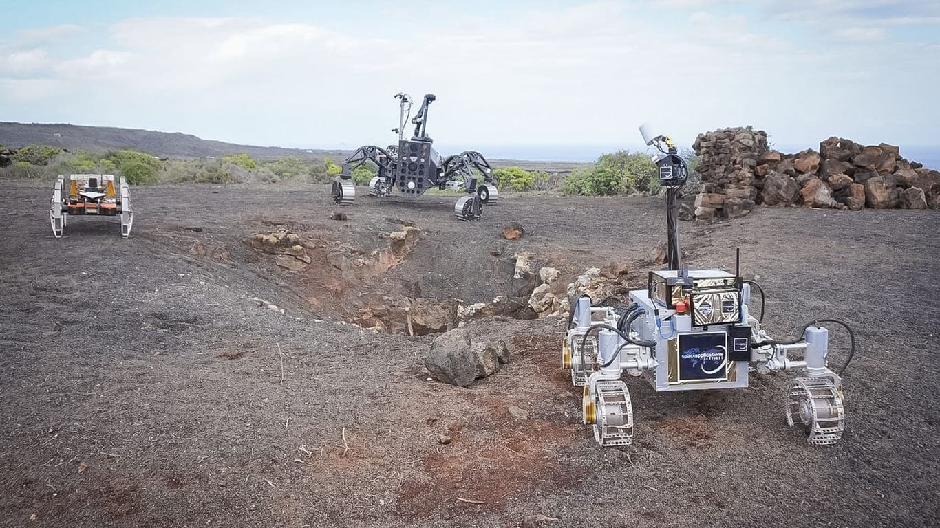 Die drei autonomen Rover Coyote III (l-r), SherpaTT und LUVMI-X erkunden den Eingang zu einer Lavahöhle (Archivfoto): In Zukunft sollen Menschen auf einer Mond-Station leben.