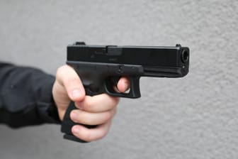 Ein Mann hält eine Schusswaffe (Symbolfoto): Die Räuber wurden von den Zeugen auf etwa 18 Jahre geschätzt.