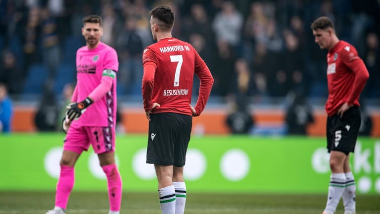 Hannovers Torwart Ron-Robert Zieler (l-r), Hannovers Max Besuschkow und Hannovers Phil Neumann stehen nach dem Schlusspfiff enttäuscht auf dem Platz: Hannover 96 hat das Niedersachsen-Derby am Sonntagabend verloren.