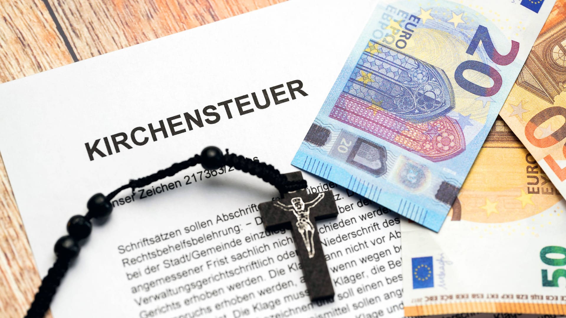 Kirchensteuer-Brief mit Euro-Scheinen (Symbolbild): Wer evangelisch, katholisch oder jüdischen Glaubens ist, muss in Deutschland Kirchensteuer zahlen.