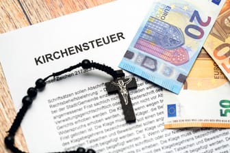 Kirchensteuer-Brief mit Euro-Scheinen (Symbolbild): Wer evangelisch, katholisch oder jüdischen Glaubens ist, muss in Deutschland Kirchensteuer zahlen.