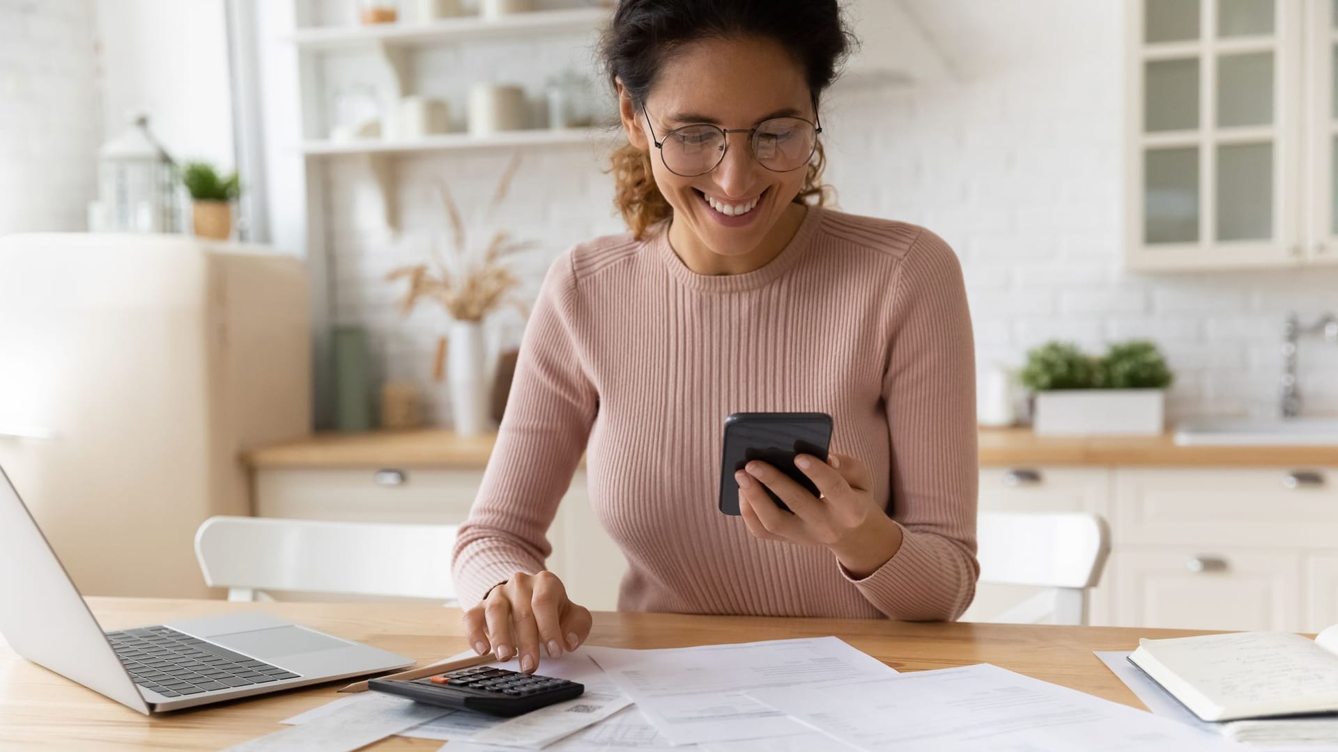 Lächelnde Frau bei der Finanzplanung (Symbolbild): Wenn Frauen Geld anlegen, sind sie meist erfolgreicher als Männer.