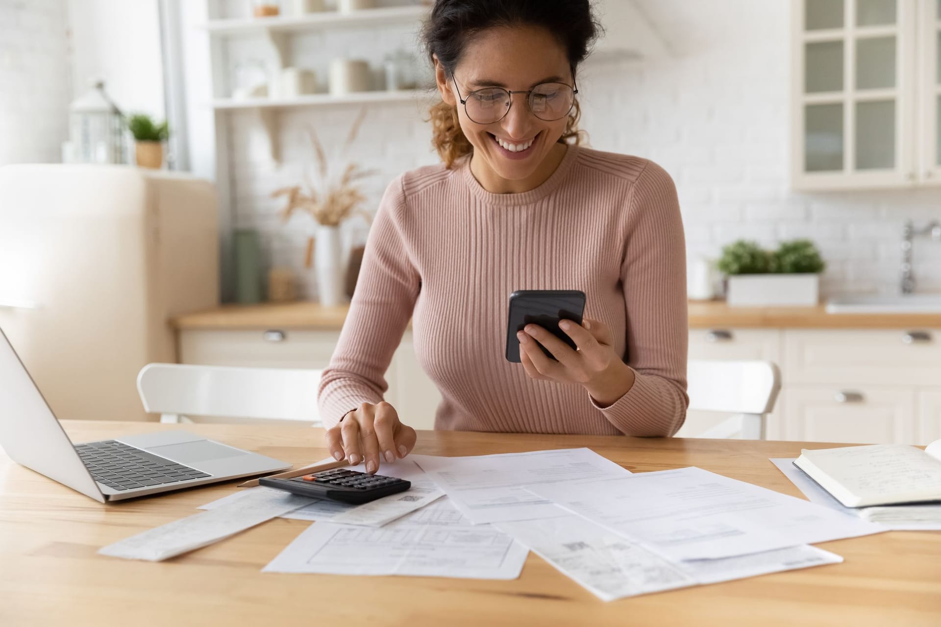 Lächelnde Frau bei der Finanzplanung (Symbolbild): Wenn Frauen Geld anlegen, sind sie meist erfolgreicher als Männer.