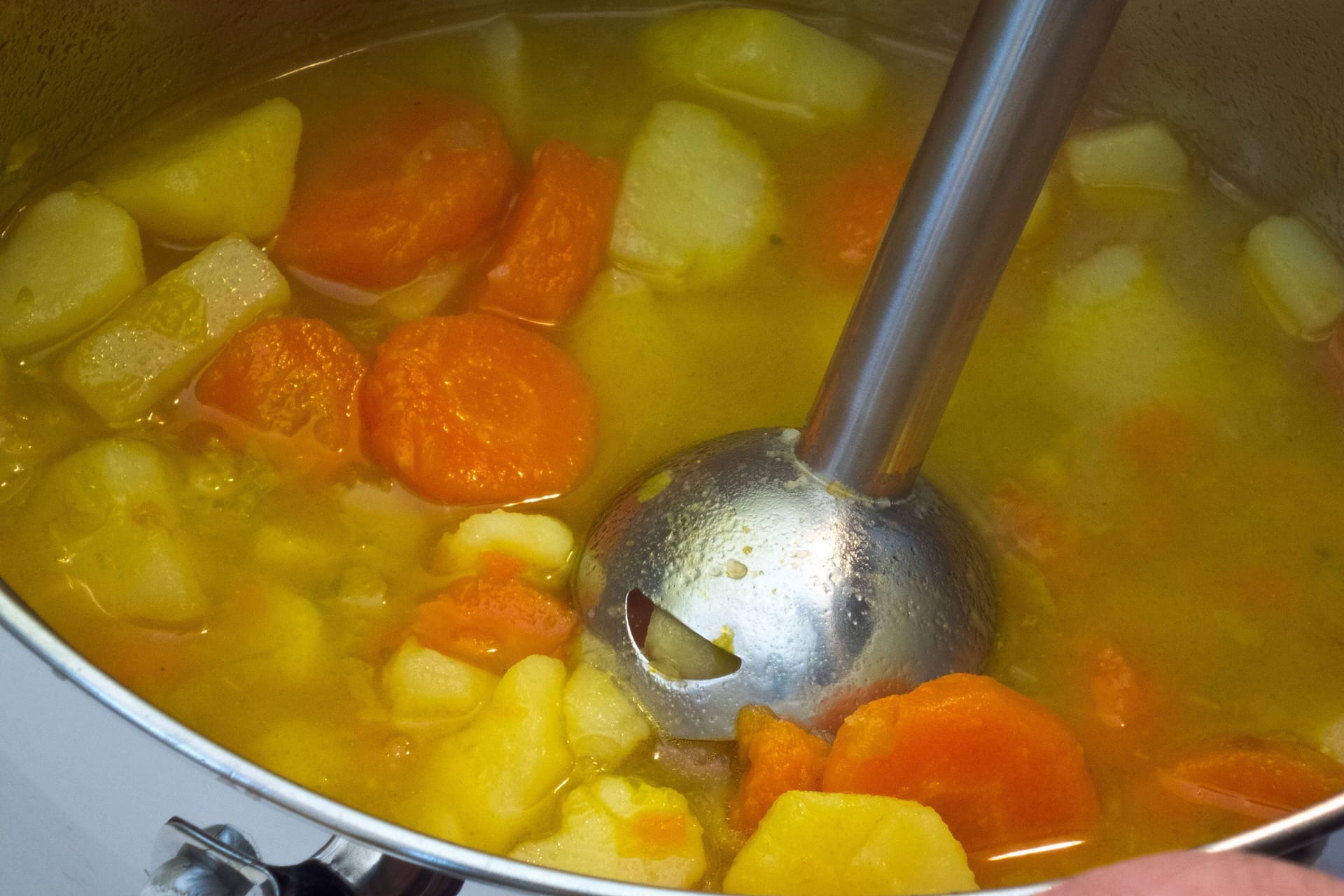 Mit dem Stabmixer die Suppe pürieren: Das Gerät darf nicht überhitzen.