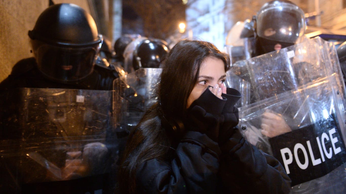 Eine Demonstrantin in Tiflis hält sich das Gesicht, nachdem die Polizei Tränengas gegen Demonstranten eingesetzt hat.