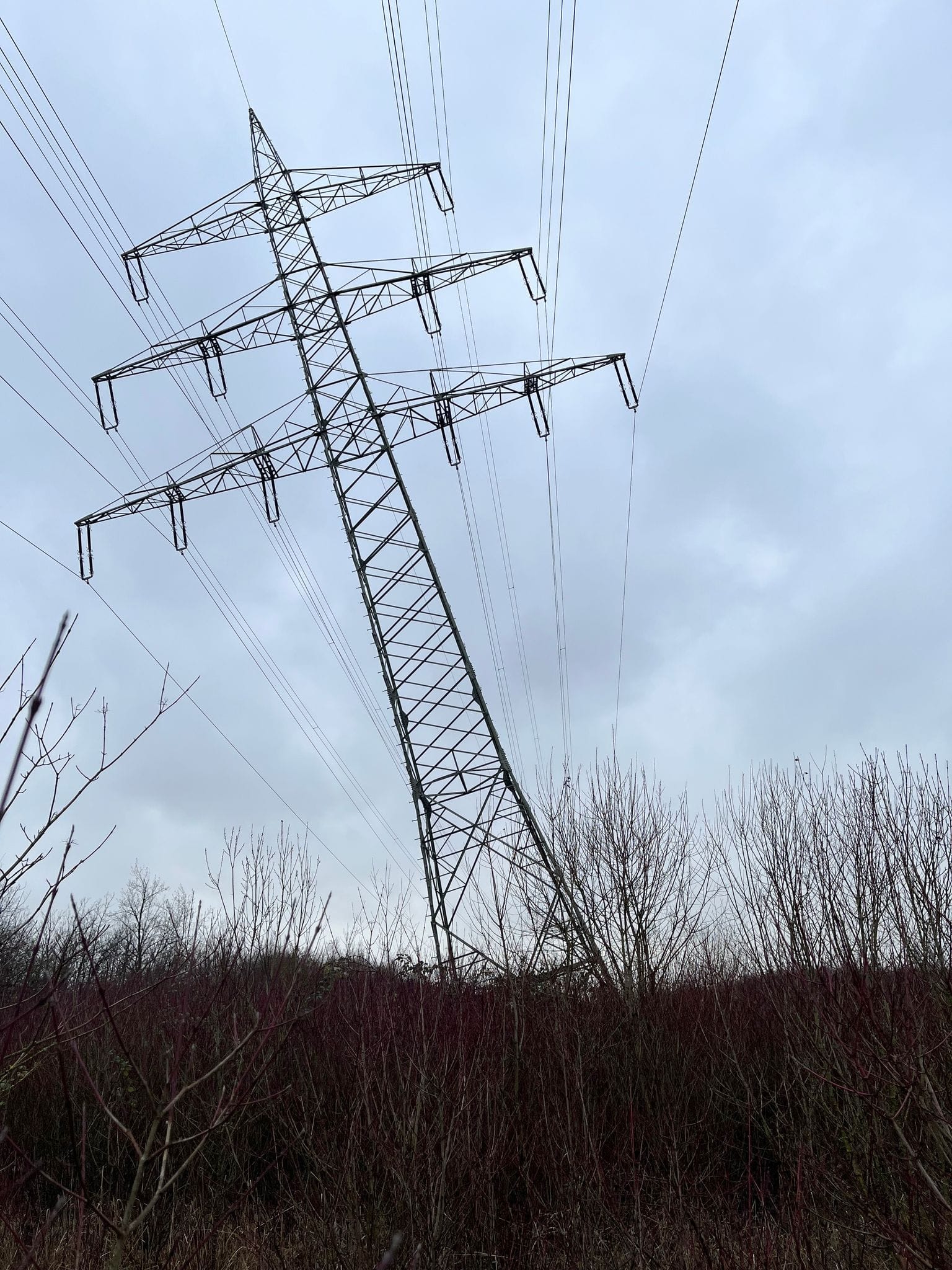 Die Polizei ermittelt: Ein Strommast am Tagebau Garzweiler steht nach einer Beschädigung schräg.