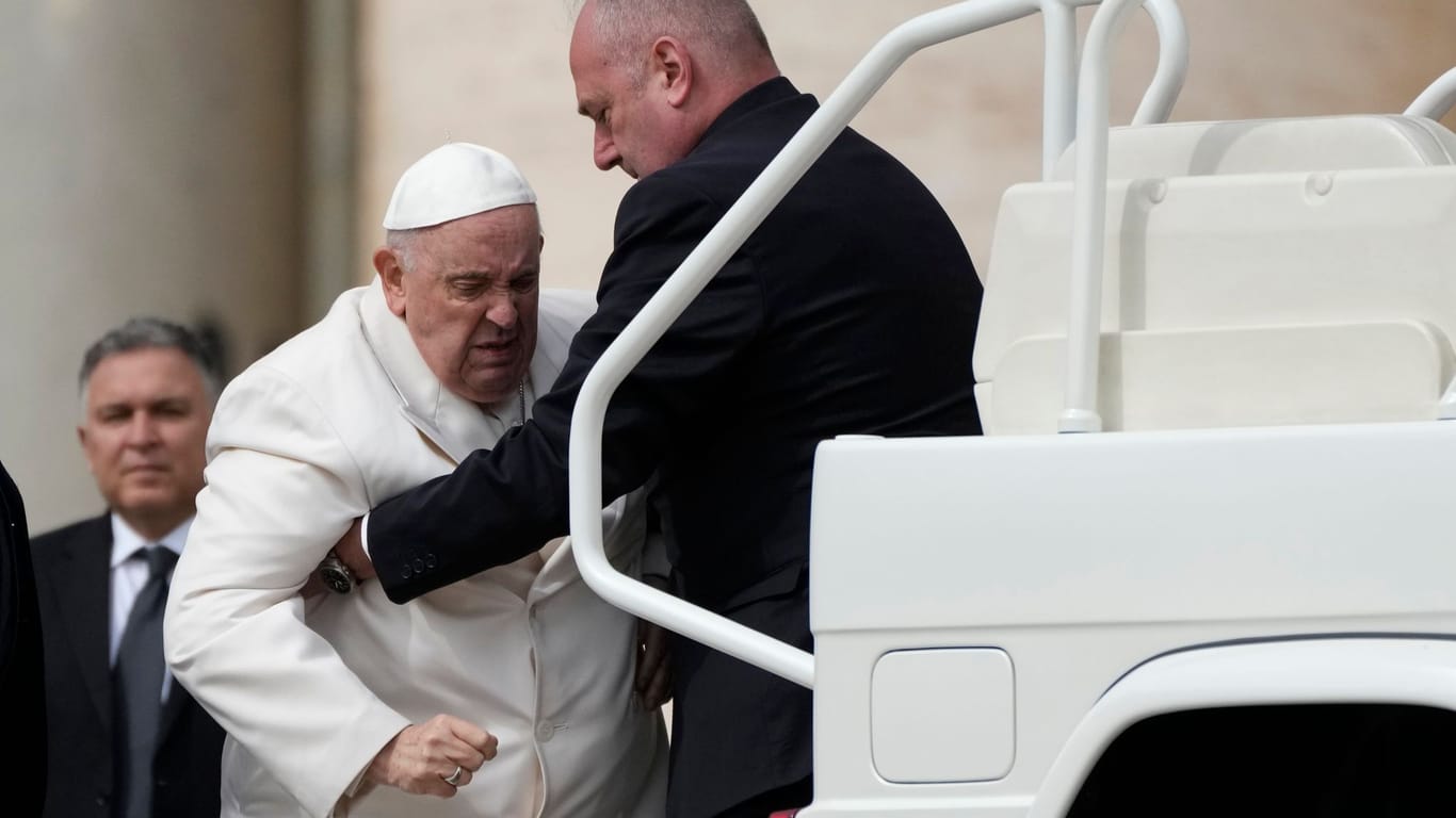 Ein Mitarbeiter hilft Papst Franziskus in sein Auto: Ein Einstieg bereitete dem Oberhaupt der katholischen Kirche sichtlich Schmerzen.